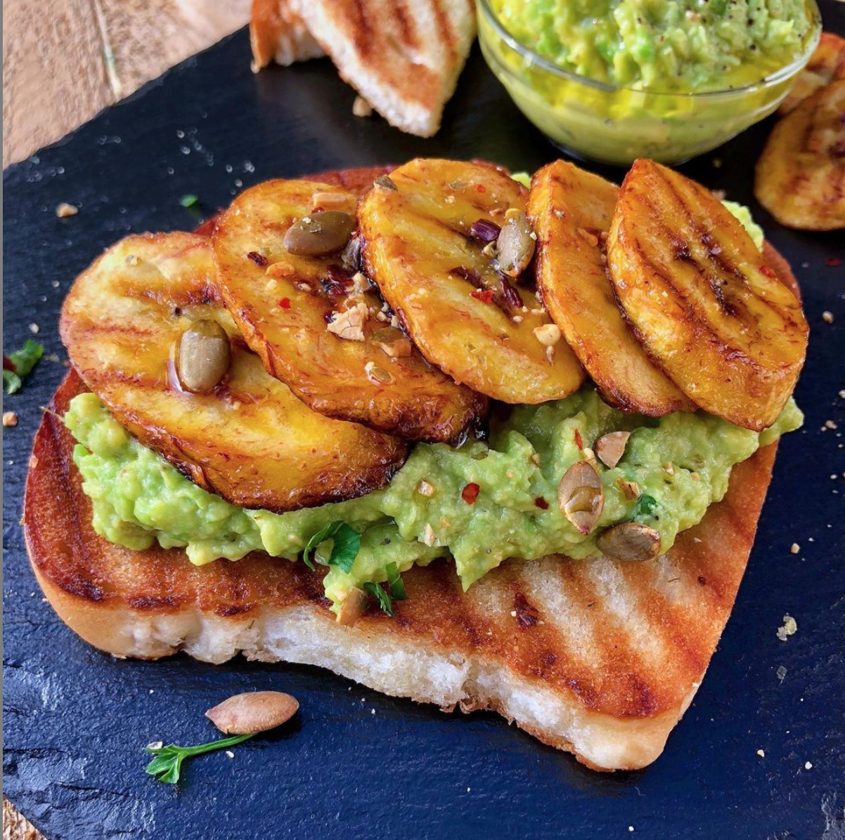 Image of toasted bread topped with mashed avocado, plantain and chilli flakes.